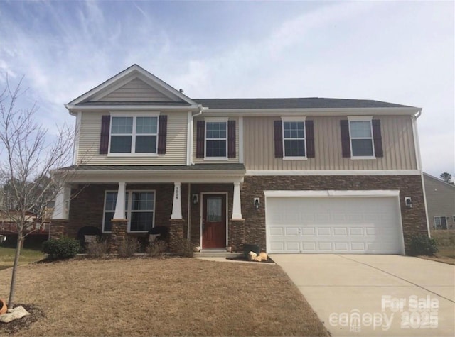 5008 Social Cir, Fort Mill, SC 29707 - view of front of house with concrete driveway, a garage, covered porch, a front lawn, and stone siding