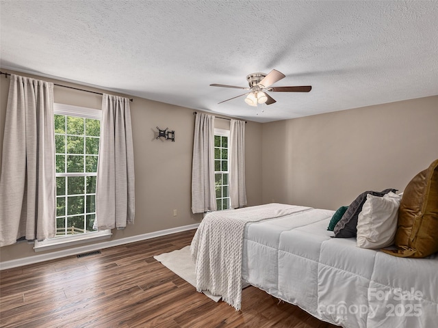 181 Junaluska Oaks Dr, Waynesville, NC 28786 - bedroom featuring wood finished floors, a textured ceiling, and a ceiling fan
