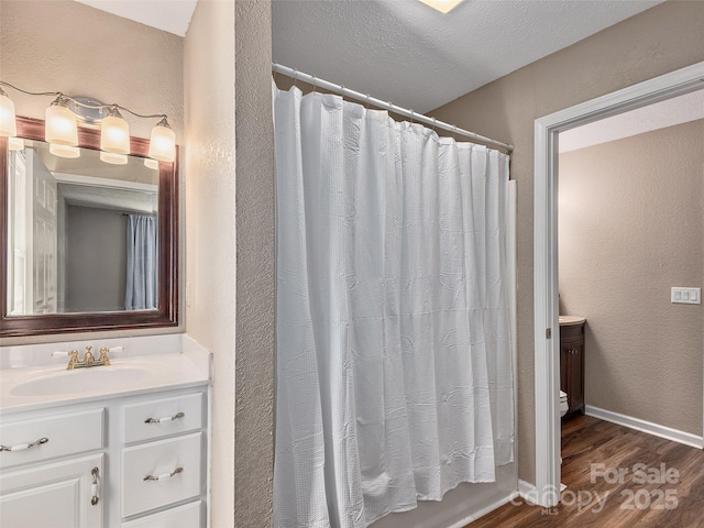 181 Junaluska Oaks Dr, Waynesville, NC 28786 - full bath with wood finished floors, vanity, curtained shower, and a textured wall