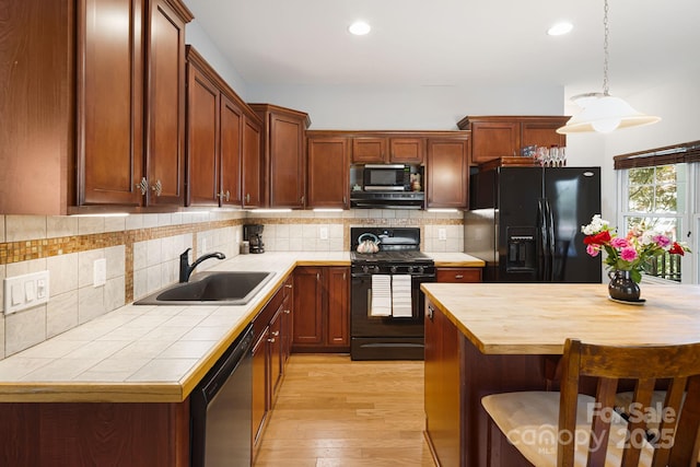 28 Richie St, Asheville, NC 28801 - kitchen featuring black appliances, a sink, light wood-style floors, tile countertops, and decorative backsplash