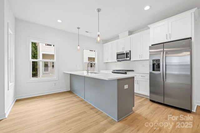 3924 Hager Dr, Charlotte, NC 28208 - kitchen featuring appliances with stainless steel finishes, a sink, light wood-type flooring, tasteful backsplash, and light countertops