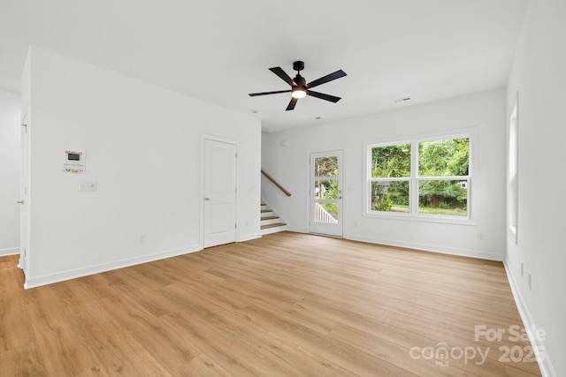 3924 Hager Dr, Charlotte, NC 28208 - unfurnished living room featuring light wood finished floors, stairway, baseboards, and a ceiling fan
