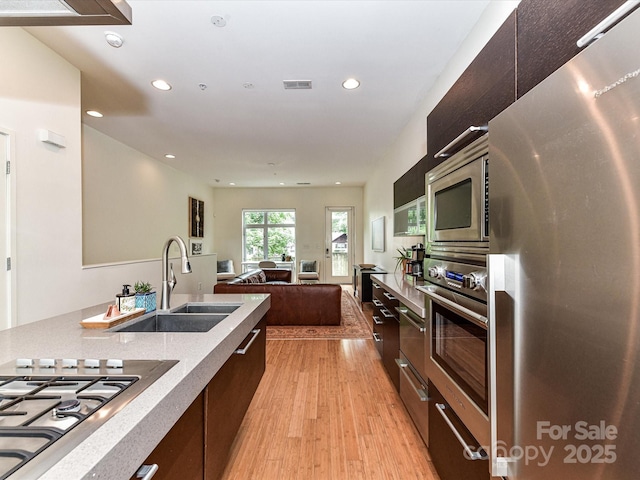314 Viburnum Way Ct, Charlotte, NC 28208 - kitchen with appliances with stainless steel finishes, a sink, modern cabinets, light wood finished floors, and recessed lighting