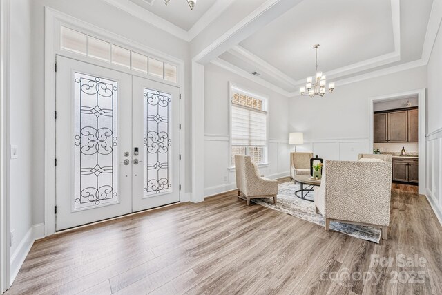 1702 Batson Creek Ln, Weddington, NC 28104 - foyer entrance featuring a chandelier, light wood finished floors, a tray ceiling, crown molding, and french doors
