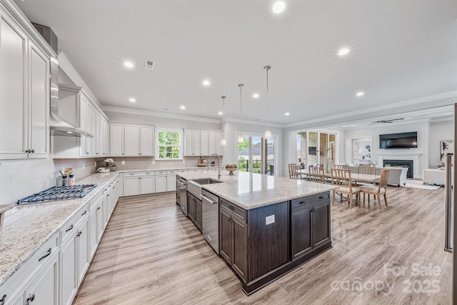 1702 Batson Creek Ln, Weddington, NC 28104 - kitchen featuring stainless steel appliances, white cabinetry, ornamental molding, light wood-type flooring, and a fireplace