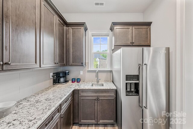 1702 Batson Creek Ln, Weddington, NC 28104 - kitchen featuring stainless steel fridge with ice dispenser, backsplash, dark brown cabinetry, and light stone countertops