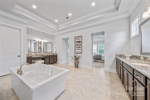1702 Batson Creek Ln, Weddington, NC 28104 - ensuite bathroom featuring a raised ceiling, two vanities, a freestanding bath, recessed lighting, and crown molding