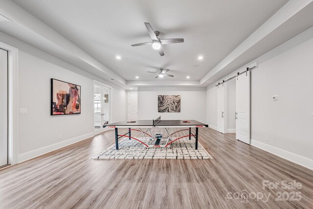 1702 Batson Creek Ln, Weddington, NC 28104 - game room featuring a barn door, recessed lighting, light wood-type flooring, ceiling fan, and a tray ceiling