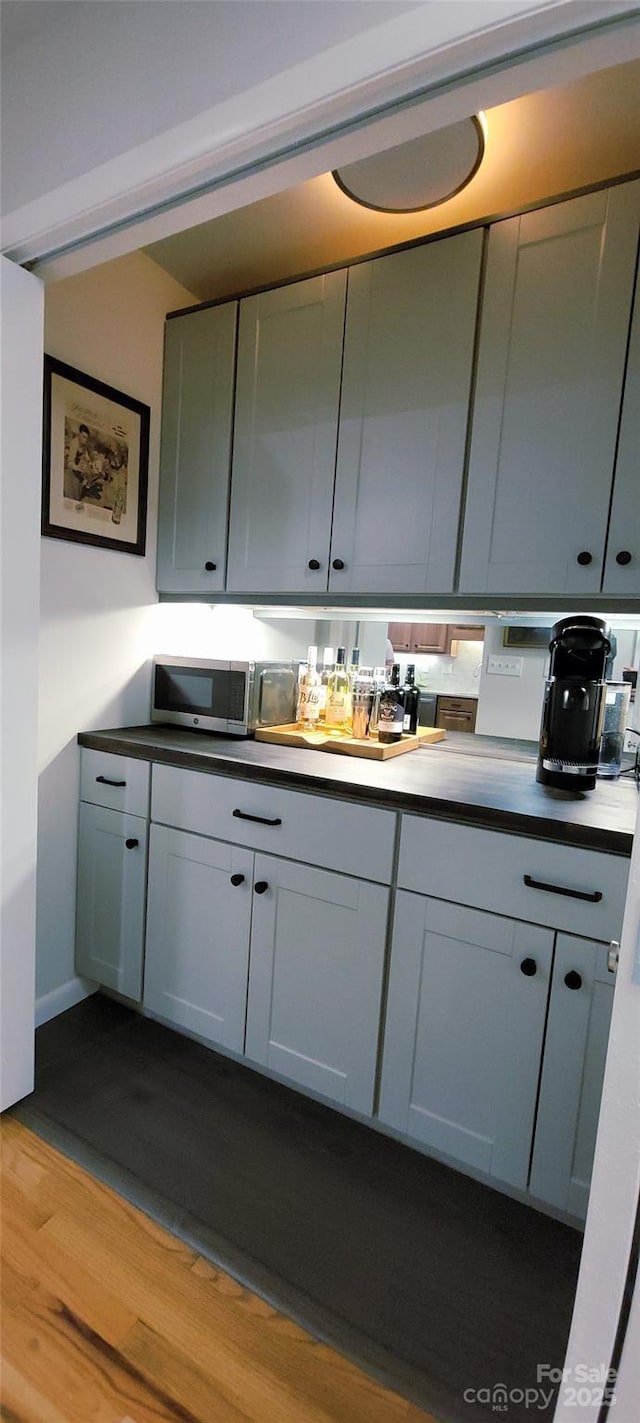 308 Woodfield Dr, Asheville, NC 28803 - bar with dark wood-style flooring and stainless steel microwave