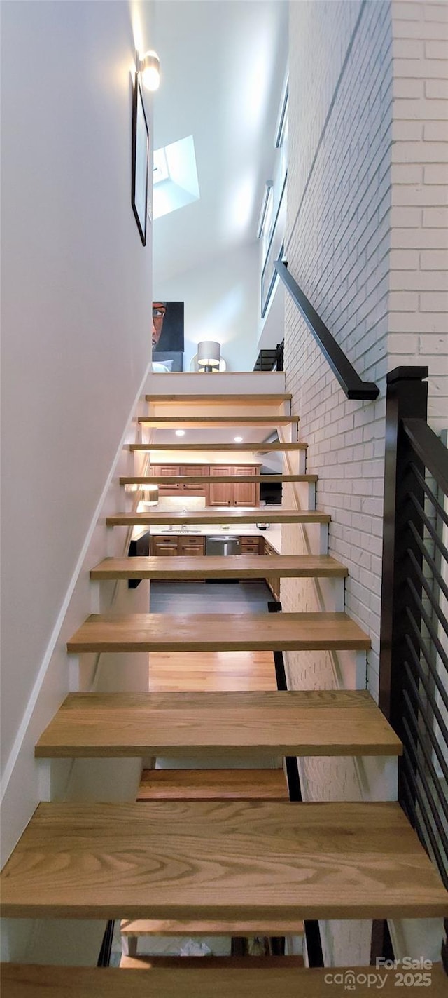 308 Woodfield Dr, Asheville, NC 28803 - stairway with a skylight, a towering ceiling, and brick wall