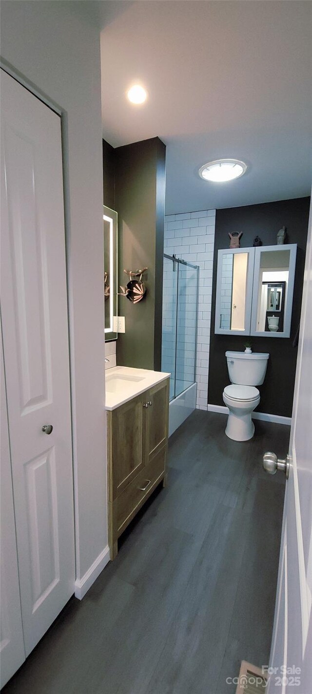 308 Woodfield Dr, Asheville, NC 28803 - full bath with toilet, a shower, vanity, wood finished floors, and baseboards