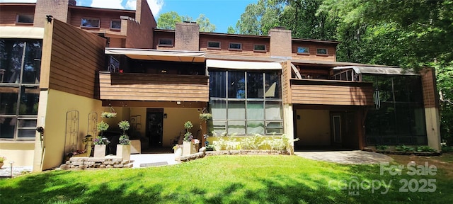 308 Woodfield Dr, Asheville, NC 28803 - rear view of house with stucco siding, a balcony, a lawn, and a chimney