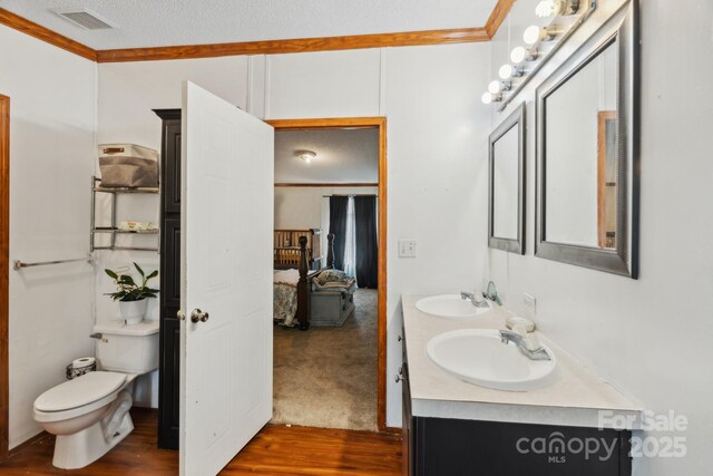 1007 W Cabaniss Rd, Shelby, NC 28150 - bathroom featuring ornamental molding, double vanity, connected bathroom, toilet, and wood finished floors