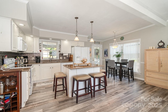 161 Badin Lake Cir, New London, NC 28127 - kitchen featuring white appliances, a sink, a center island, white cabinetry, and a kitchen bar