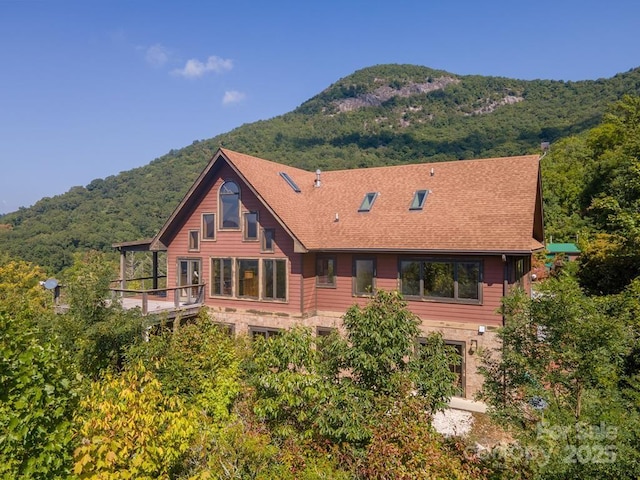 37 Jones Knob Rd, Franklin, NC 28734 - rear view of house with a mountain view, stone siding, a shingled roof, a balcony, and a forest view