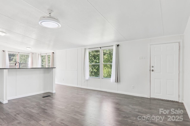 85 Star Flower Rd, Alexander, NC 28701 - unfurnished living room featuring wood finished floors, baseboards, and a sink