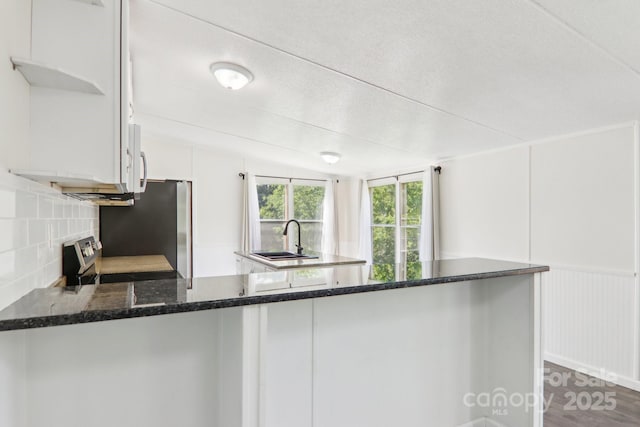 85 Star Flower Rd, Alexander, NC 28701 - kitchen with a sink, appliances with stainless steel finishes, a peninsula, tasteful backsplash, and white cabinetry