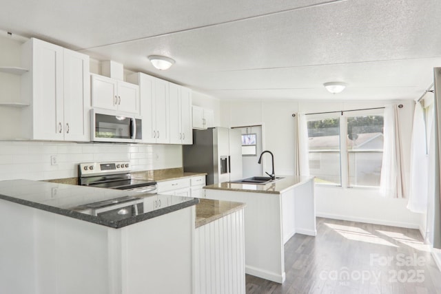 85 Star Flower Rd, Alexander, NC 28701 - kitchen with stainless steel appliances, a sink, a kitchen island with sink, open shelves, and tasteful backsplash