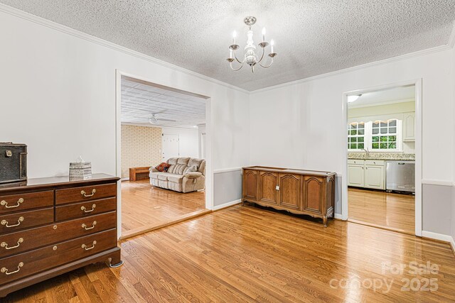 38 Westridge Dr, Asheville, NC 28803 - dining room featuring a textured ceiling, crown molding, light wood-type flooring, a chandelier, and baseboards