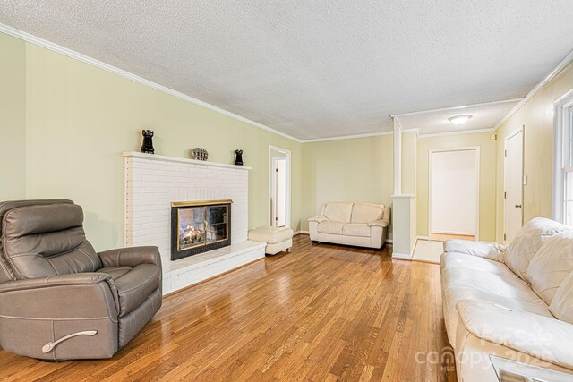 38 Westridge Dr, Asheville, NC 28803 - living area featuring a textured ceiling, wood finished floors, crown molding, a fireplace, and baseboards