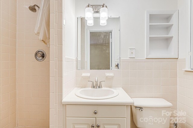 38 Westridge Dr, Asheville, NC 28803 - bathroom with a tile shower, vanity, toilet, and tile walls
