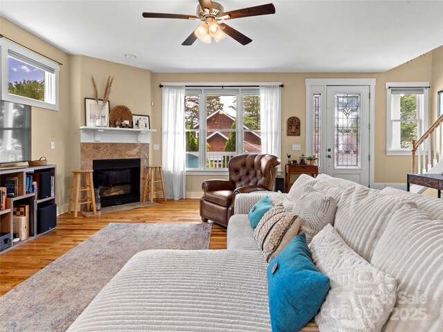 7 Oakhaven Ter, Asheville, NC 28803 - living room with a ceiling fan, wood finished floors, a tiled fireplace, baseboards, and stairway