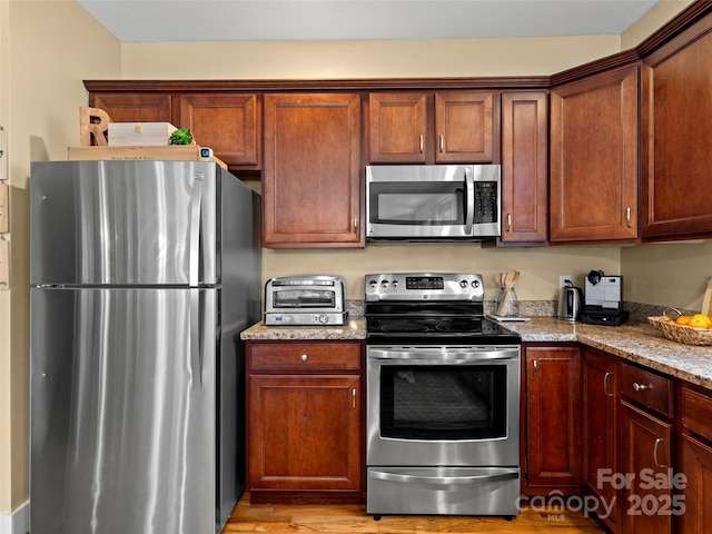 7 Oakhaven Ter, Asheville, NC 28803 - kitchen featuring stainless steel appliances, light stone counters, and light wood-style flooring