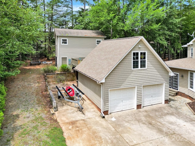 832 Kemp Rd, Mooresville, NC 28117 - view of front facade with a garage, concrete driveway, a shingled roof, and view of wooded area