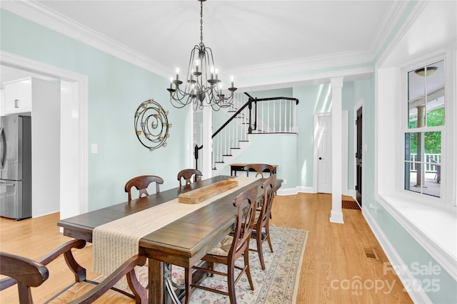 832 Kemp Rd, Mooresville, NC 28117 - dining space with stairway, light wood-style flooring, crown molding, a chandelier, and ornate columns