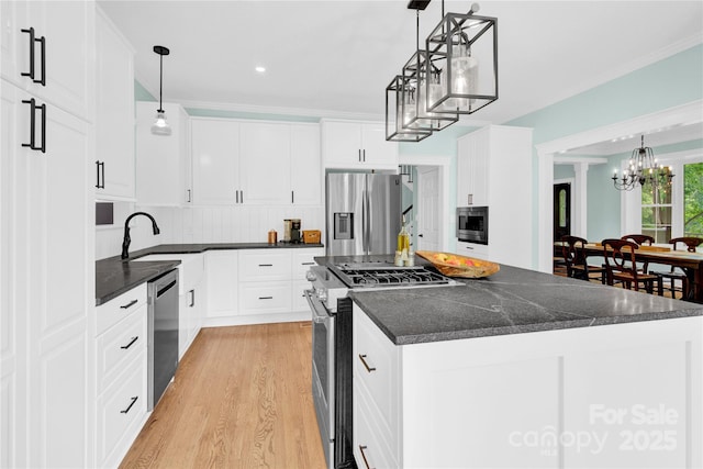 832 Kemp Rd, Mooresville, NC 28117 - kitchen featuring stainless steel appliances, a chandelier, light wood-type flooring, a kitchen island, and crown molding
