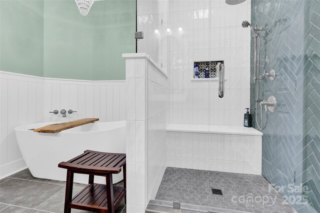 832 Kemp Rd, Mooresville, NC 28117 - full bath featuring a soaking tub, a shower stall, tile patterned floors, and a wainscoted wall