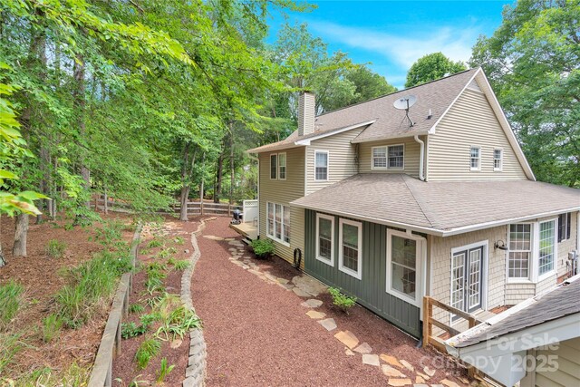 832 Kemp Rd, Mooresville, NC 28117 - rear view of property featuring roof with shingles, a chimney, and board and batten siding