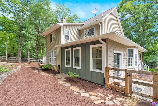 832 Kemp Rd, Mooresville, NC 28117 - view of property exterior with board and batten siding, a chimney, and a shingled roof