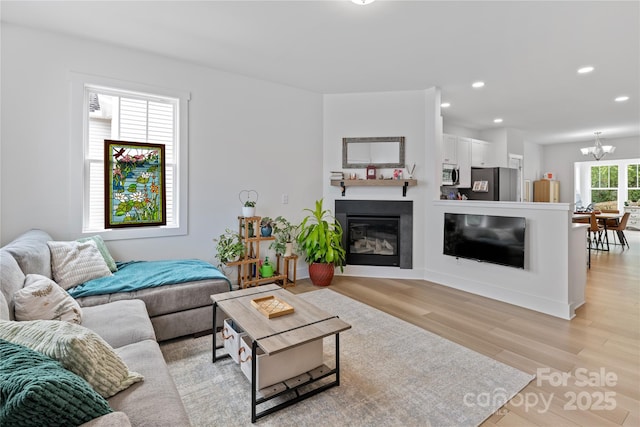 212 Rockrose Ct, Asheville, NC 28803 - living room with light wood finished floors, recessed lighting, a chandelier, and a glass covered fireplace