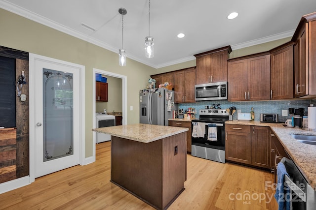 226 Stockwood Ln, Stanley, NC 28164 - kitchen with stainless steel appliances, ornamental molding, light stone counters, light wood finished floors, and a kitchen island