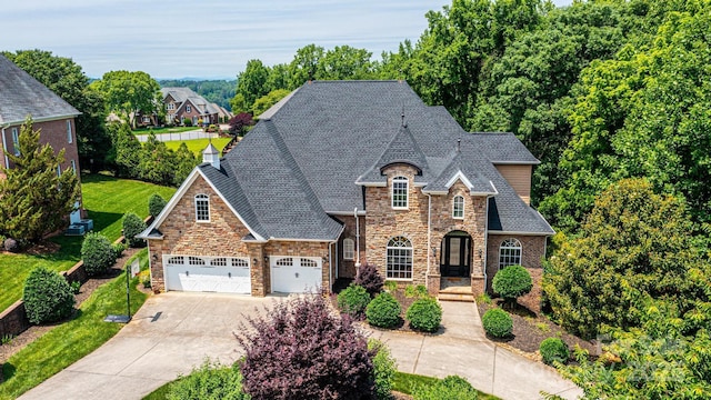 4431 1st Street Dr NW, Hickory, NC 28601 - french country style house featuring stone siding, concrete driveway, a shingled roof, a garage, and a front lawn