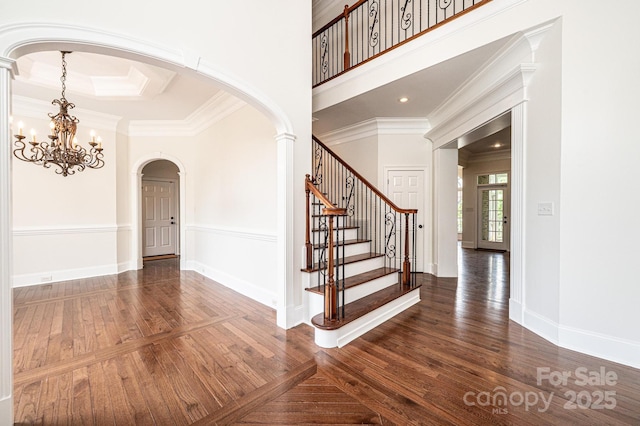 4431 1st Street Dr NW, Hickory, NC 28601 - entryway with arched walkways, wood finished floors, a chandelier, crown molding, and stairs