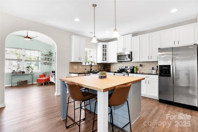 2210 Winding River Dr, Charlotte, NC 28214 - kitchen featuring stainless steel appliances, butcher block counters, plenty of natural light, arched walkways, and recessed lighting
