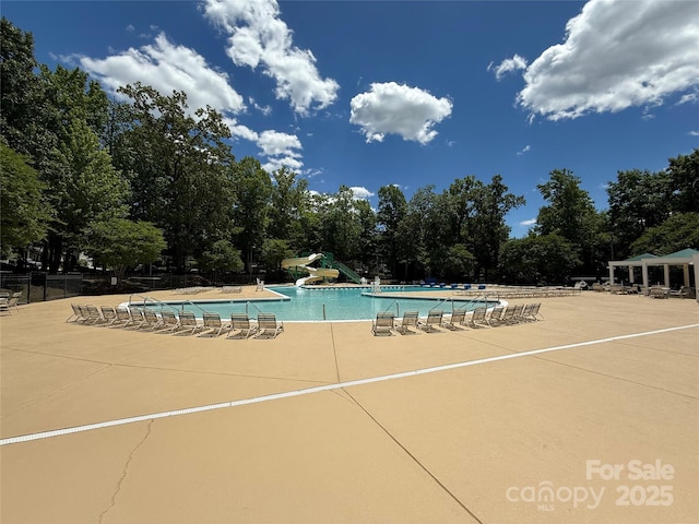 2210 Winding River Dr, Charlotte, NC 28214 - community pool with a water slide, a patio, and view of wooded area