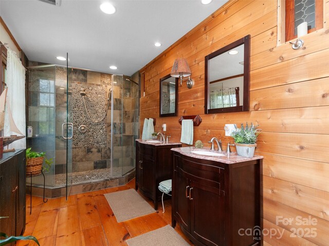 229 Crabtree Mountain Rd, Canton, NC 28716 - full bathroom with two vanities, a shower stall, wood-type flooring, recessed lighting, and wood walls