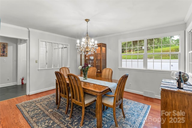 34 Westridge Dr, Asheville, NC 28803 - dining room featuring a chandelier, wood finished floors, ornamental molding, and baseboards