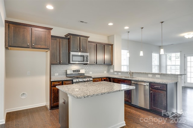 4051 Whittier Ln, Fort Mill, SC 29708 - kitchen with stainless steel appliances, a peninsula, dark wood-type flooring, dark brown cabinetry, and backsplash