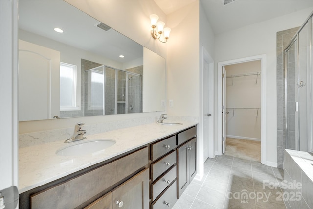 4051 Whittier Ln, Fort Mill, SC 29708 - bathroom with a shower stall, tile patterned flooring, double vanity, a spacious closet, and recessed lighting