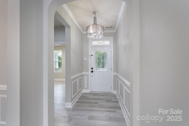 1211 Gold Rush Ct, Fort Mill, SC 29708 - foyer with a chandelier, ornamental molding, light wood-style flooring, a decorative wall, and wainscoting