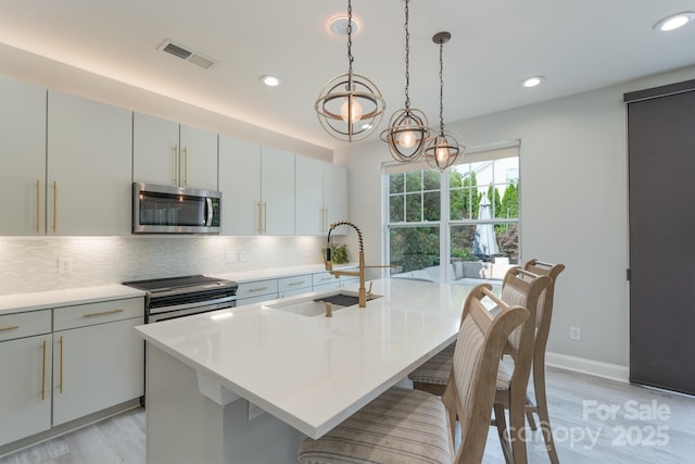 1211 Gold Rush Ct, Fort Mill, SC 29708 - kitchen with stainless steel microwave, light wood-style floors, recessed lighting, tasteful backsplash, and a kitchen bar
