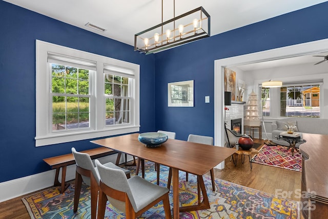 140 Pennsylvania Ave, Asheville, NC 28806 - dining room featuring wood finished floors, healthy amount of natural light, a lit fireplace, and baseboards
