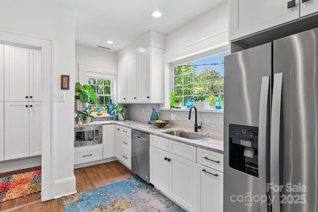 140 Pennsylvania Ave, Asheville, NC 28806 - kitchen with stainless steel appliances, a sink, dark wood-type flooring, white cabinetry, and light stone countertops