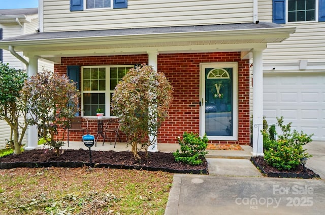 2234 Dion Ave, Charlotte, NC 28212 - doorway to property featuring brick siding, a garage, and covered porch