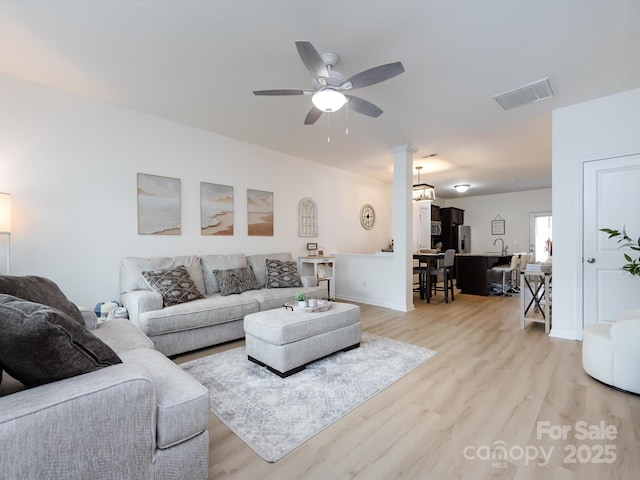 13422 Calloway Glen Dr, Charlotte, NC 28273 - living room featuring light wood-style floors, ceiling fan, decorative columns, and baseboards