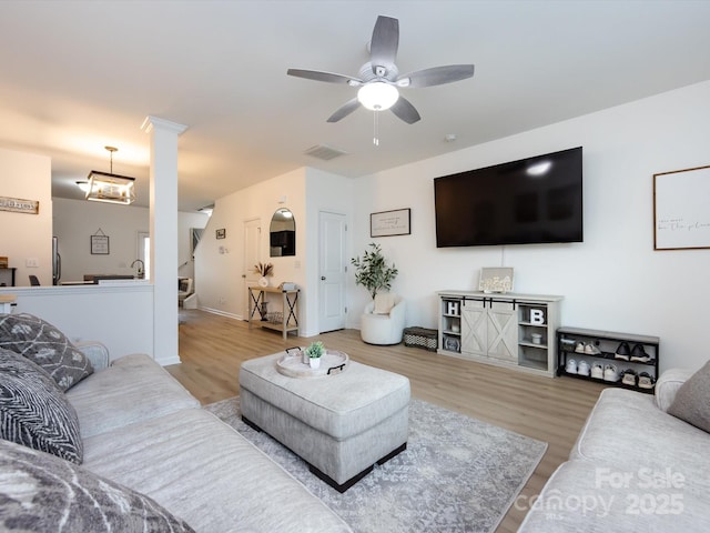13422 Calloway Glen Dr, Charlotte, NC 28273 - living room featuring wood finished floors, ceiling fan, decorative columns, and baseboards